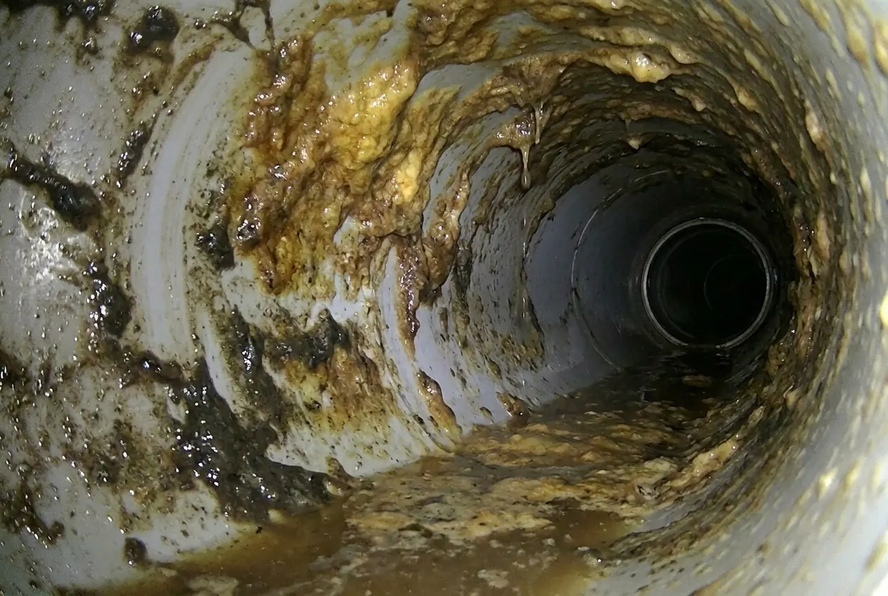 Potrubí ucpané tukem a usazeninami před zásahem